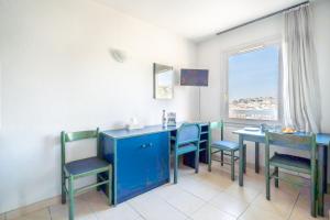 a dining room with blue chairs and a table and a window at Studio hypercentre gare in Nice