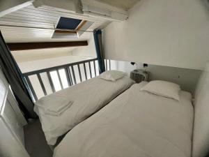 two beds in a small room with a window at Appartement Boulevard de la Plage in Arcachon +8 photos