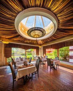 a dining room with tables and chairs and a chandelier at Mesés Shiraz Hotel Superior-Adults only in Egerszalók