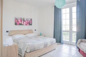 sypialnia z łóżkiem i dużym oknem w obiekcie 065 - VILLA LETIZIA, Elegante 2 PISCINA e Natura, 10 minuti da MARE e SPIAGGIE w mieście Casarza Ligure