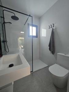 a white bathroom with a sink and a toilet at Villa Marismas in Barbate +39 photos