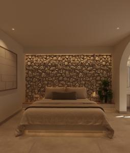 a bedroom with a large bed with a stone wall at Tinas Plus Hotel in Faliraki +87 photos