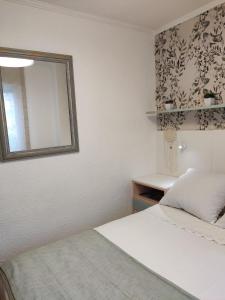 a bedroom with two beds and a mirror on the wall at Rooms Villaverde in Madrid