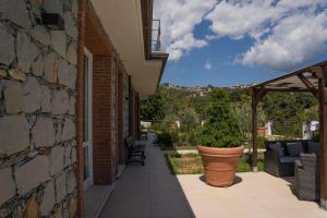 patio z rośliną w garnku obok budynku w obiekcie 065 - VILLA LETIZIA, Elegante 2 PISCINA e Natura, 10 minuti da MARE e SPIAGGIE w mieście Casarza Ligure +30 zdjęć