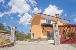 dom z bramą przed nim w obiekcie 065 - VILLA LETIZIA, Elegante 2 PISCINA e Natura, 10 minuti da MARE e SPIAGGIE w mieście Casarza Ligure