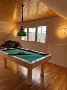 una mesa de billar en una sala de estar con techo en Villa Le domaine des Reves, en Hauteville-Lompnes