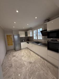 cocina grande con armarios blancos y electrodomésticos de acero inoxidable en Villa Le domaine des Reves, en Hauteville-Lompnes