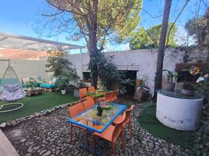 patio ze stołem, krzesłami i kominkiem w obiekcie Casa de Huéspedes con encanto El Sueño del Quijote w mieście Alcalá de Henares