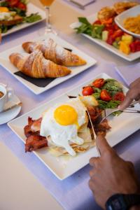 a table topped with plates of food with eggs and bacon at The Purple Hotel - Adults Only in San Antonio