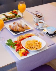 a table with plates of breakfast foods and drinks at The Purple Hotel - Adults Only in San Antonio