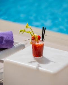 a drink sitting on a table next to a pool at The Purple Hotel - Adults Only in San Antonio