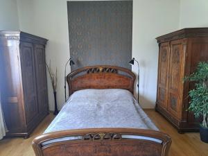 a bedroom with a wooden bed and wooden cabinets at Milán Apartment in Nyíregyháza