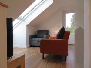 a living room with a couch and a chair at The Loft at Log Ness in Inverness