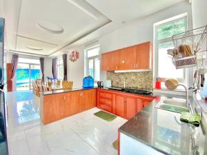 a kitchen with wooden cabinets and a counter top at Serina Villa Pool Beach in Vung Tau
