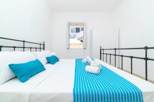 a bedroom with a bed with blue and white pillows at Casa degli Oleandri in Ostuni