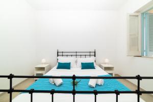 a bedroom with a bed with blue and white pillows at Casa degli Oleandri in Ostuni