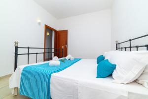 a bedroom with a bed with blue and white pillows at Casa degli Oleandri in Ostuni +55 photos