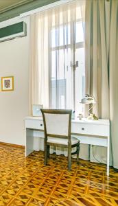 a desk and a chair in a room with a window at White Lilies Spacious 2-Bedroom Sea View in Baku +55 photos