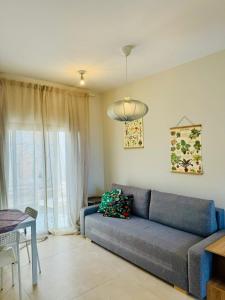 a living room with a blue couch and a table at מול ים המלח in Ovnat