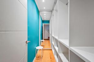 a hallway with a blue door and a stool at Sunny Side Apartment Wembley in Harrow on the Hill
