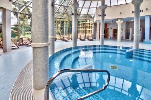 a large swimming pool in a building with a building at Les Magnolias Hotel in Primorsko