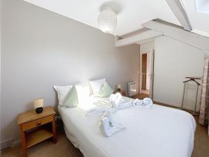 a bedroom with a white bed with towels on it at Maison Auriane 3 minutes de la gare in Margny-lès-Compiègne