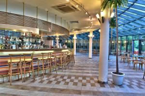 a restaurant with a bar with chairs and tables at Les Magnolias Hotel in Primorsko