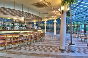 Les Magnolias Hotel في بريمورسكو: مطعم فيه بار فيه كراسي وطاولات