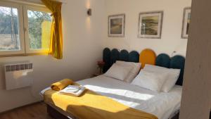a bedroom with a bed with a yellow blanket on it at Domki Przy Pracowni in Wytowno