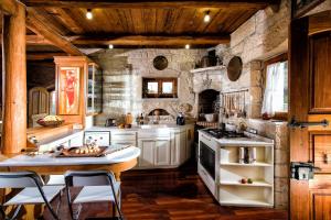 a kitchen with stone walls and wooden ceilings at Panoramic View Villa in OliveGroves in Heraklio