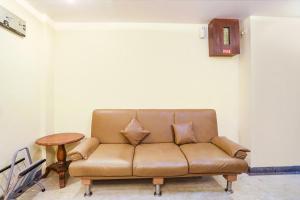 a brown couch in a living room with a table at FabHotel Shubhangan - Nr Bandra in Mumbai +20 photos