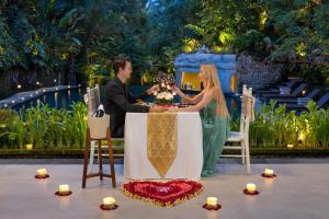 ウブドにあるSakti Garden Resort & Spaのワインを飲みながら座る男女 +37枚の写真