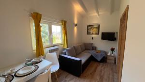 a living room with a couch and a table at Domki Przy Pracowni in Wytowno