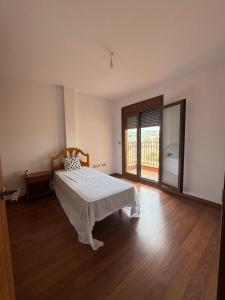 ein Schlafzimmer mit einem Bett und einem großen Fenster in der Unterkunft Anosa in Castalla