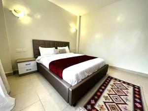 a bedroom with a large bed and a rug at Nakuru CBD Luxury Suites With Heated Pool, GYM, Secure Parking in Nakuru