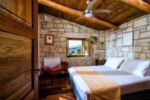 a bedroom with a bed and a stone wall at Panoramic View Villa in OliveGroves in Heraklio
