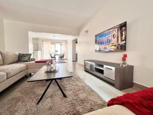 a living room with a couch and a tv on a wall at Nakuru CBD Luxury Suites With Heated Pool, GYM, Secure Parking in Nakuru