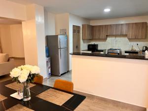 a kitchen with a table and a refrigerator at Nakuru CBD Luxury Suites With Heated Pool, GYM, Secure Parking in Nakuru