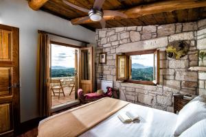 a bedroom with a bed and a stone wall at Panoramic View Villa in OliveGroves in Heraklio