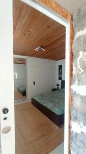a bedroom with a bed and a stone wall at Kanela Guest House B-side in Machico