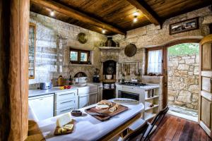 a kitchen with white appliances and a stone wall at Panoramic View Villa in OliveGroves in Heraklio