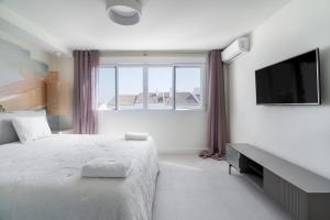a white bedroom with a bed and a large window at Casa Lola in Sitio de Calahonda +13 photos