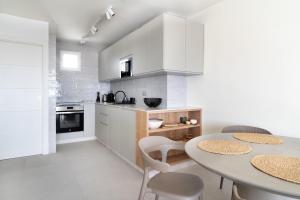 a kitchen with white cabinets and a table and chairs at Casa Lola in Sitio de Calahonda