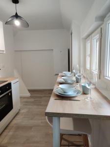 a kitchen with a table with plates and wine glasses at Maison Rénovée & Spacieuse, Idéale Familles & Groupes, Proche Aéroport in Beauvais