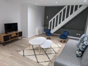 a living room with a couch and a table at Maison Rénovée & Spacieuse, Idéale Familles & Groupes, Proche Aéroport in Beauvais