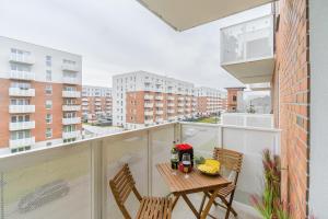 a balcony with two chairs and a table with flowers on it at Lumina I Comfy Apartments with Balcony I Parking I Pasaż Łódzki in Łódź +38 photos