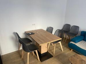 Zimmer mit einem Tisch, Stühlen und einem Sofa in der Unterkunft Patrimoine et immobilier Villas du Lac in Soustons