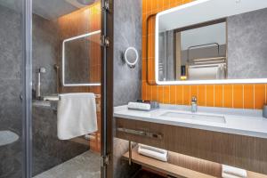 un bagno con lavandino e specchio di Home2 Suite by Hilton Foshan Lishui a Foshan Altre 12 foto
