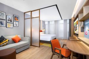 una camera d'albergo con un letto, un divano e un tavolo di Home2 Suite by Hilton Foshan Lishui a Foshan