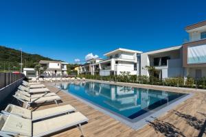 a swimming pool with lounge chairs next to a house at IseoLakeRental - Casa Marcellino in Clusane sul Lago